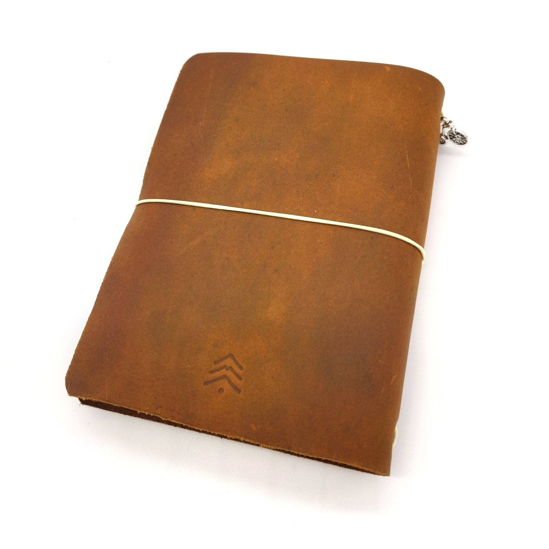 A6 cognac leather traveler's notebook with a cream elastic and bus charm